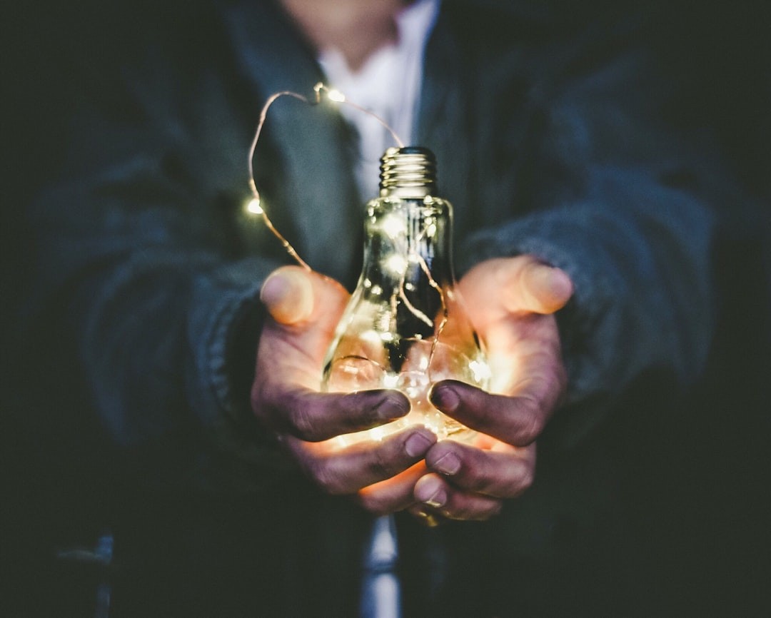 person holding incandescent bulb